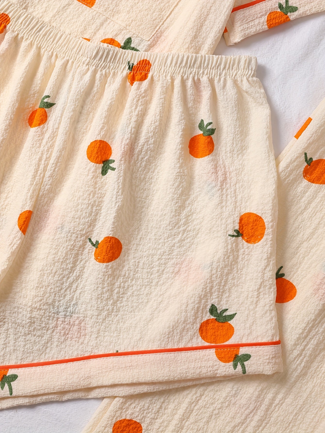 Tredelad pyjamas i mjukt tyg med lekfullt tryck med Apelsin